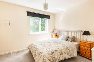 a white bedroom with a bed and a window at Charming Entire 2-Bedroom House in Milton Keynes in Milton Keynes
