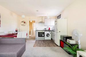 a kitchen with a white refrigerator and a table at Charming Entire 2-Bedroom House in Milton Keynes in Milton Keynes