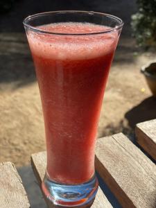 a red drink in a glass sitting on a table at Keshiya Holiday Home in Nuwara Eliya