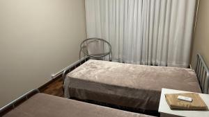una habitación de hospital con 2 camas y una silla en Pertinho CONSULADO AMERICANO Ar Condicionado 2 quartos Até 5 pessoas Av Carlos Gomes, en Porto Alegre