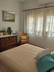 Lecrin的住宿－Casa El Naranjo Azul Granada，一间卧室配有一张床、一个梳妆台和一扇窗户。