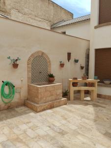 Lecrin的住宿－Casa El Naranjo Azul Granada，庭院设有喷泉和木桌。