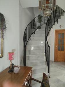 Lecrin的住宿－Casa El Naranjo Azul Granada，客厅里带黑色栏杆的楼梯