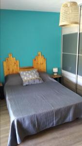 Bett in einem Zimmer mit blauer Wand in der Unterkunft Tilagonbleu à la Saline les Bains in La Saline Les hauts 