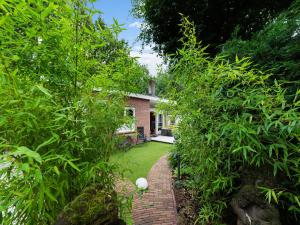 a garden with a brick path leading to a house at Holiday house in Bergen with sauna at the forest in Bergen
