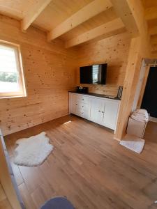 にあるSłodki Zakątek Spa Jacuzzi&Saunaの木造キャビン内のリビングルーム(テレビ付)