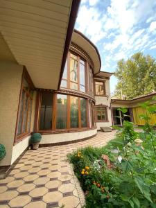 a house with a patio and a yard with flowers at Sultan Saray in Osh