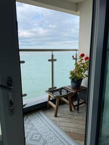 a balcony with a table and a cross on the water at Doc Fictoria in Caernarfon