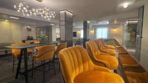une salle à manger avec une table et des chaises jaunes dans l'établissement Caesar Premier Jerusalem Hotel, à Jérusalem
