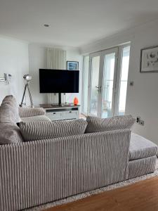 a striped couch in a living room with a flat screen tv at Doc Fictoria in Caernarfon