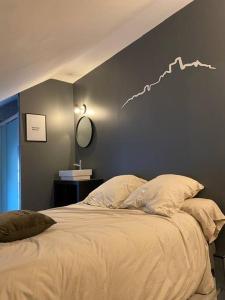sypialnia z dużym łóżkiem z wykresem na ścianie w obiekcie La Maison des Pressoirs w mieście Sancerre