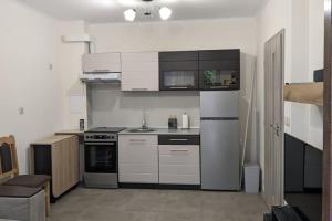 uma cozinha com armários brancos e um frigorífico branco em Сарафово Център em Burgas