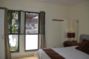 ein Schlafzimmer mit einem Bett und einem großen Fenster in der Unterkunft Artists Colony Inn Zefat in Safed