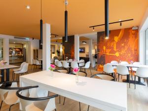 a dining room with white tables and chairs at B&B Hotel Essen in Essen