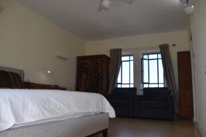 a bedroom with a bed and a couch and windows at Artists Colony Inn Zefat in Safed