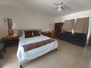 a bedroom with a bed and a couch and a ceiling fan at Artists Colony Inn Zefat in Safed