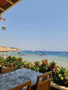 a table with chairs and a view of the beach at Amazing flat in Gardenia plaza in Sharm El Sheikh