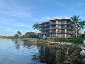 a large building next to a river with palm trees at Tropical Paradise Key West in Key West