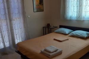a bedroom with a bed with two towels on it at The Ruby Cottage in Sami