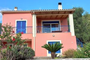 a pink house with a balcony at The Ruby Cottage in Sami