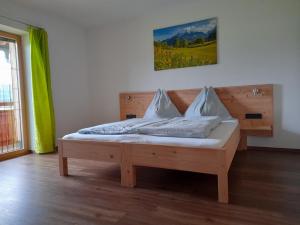 una cama de madera con almohadas en una habitación en Ferienwohnung Kramerhof, en Ebbs
