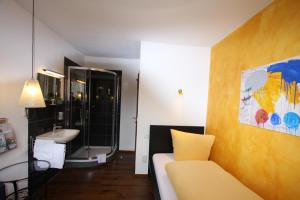 a bathroom with a couch and a sink in a room at Stadthotel Kleiner Berg in Friedrichshafen