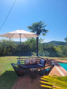 - une terrasse avec une table et un parasol à côté de la piscine dans l'établissement Le Baron Perché, à Saint-Cyprien