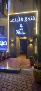 flamingo hotel irbid في Zabdah: علامة على جانب مبنى به نباتات