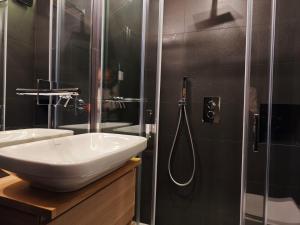 a bathroom with a sink and a shower at Hostdomus - Oak Luxury Suite in Sestriere