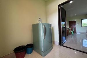 una nevera de acero inoxidable en una cocina junto a una puerta en SB Park Mansion, en Phuket