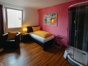 um quarto com uma cama, uma cadeira e uma janela em Stadthotel Kleiner Berg em Friedrichshafen
