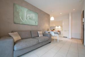 ein Wohnzimmer mit einem Sofa und einer Küche in der Unterkunft Prestige du Lac 27 - Happy Rentals in Lugano