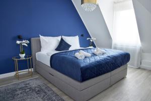 - une chambre bleue avec un lit avec deux animaux rembourrés dans l'établissement SCHLOSSBERG RESIDENCES - XXL-Design-Apartment mit Schlossblick für bis zu 12 Personen, à Schwetzingen 36 autres photos
