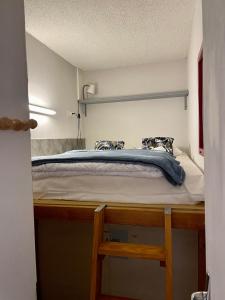 uma cama num quarto com uma plataforma de madeira em Appartement T2 + cabine em Cauterets