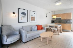 a living room with a couch and a table and a kitchen at HD Parque Cristobal Tenerife in Playa de las Americas
