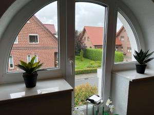 an arched window with two potted plants on a window sill at Ferienwohnung Wicki in Kluse
