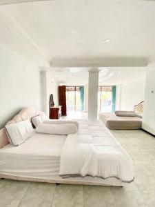 Habitación blanca grande con 2 camas. en Villa Hijau Bandungan, en Bandungan