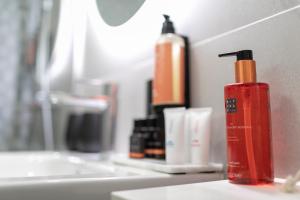 a red bottle of soap sitting on a bathroom counter at HD Parque Cristobal Tenerife in Playa de las Americas
