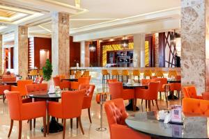 a restaurant with orange chairs and tables and a bar at Pickalbatros White Beach Resort - Hurghada in Hurghada