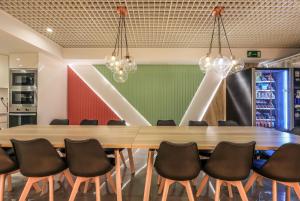 uma sala de conferências com uma mesa de madeira e cadeiras em AmazINN Places Chamberi em Madrid