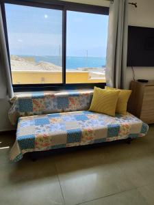 um sofá sentado em frente a uma grande janela em זוהר במדבר ים המלח em Neve Zohar