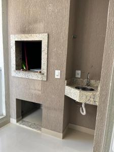 a bathroom with a sink and a fireplace at Apartamento à 400m do mar in Itapema