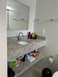 a bathroom counter with a sink and a mirror at Apartamento à 400m do mar in Itapema