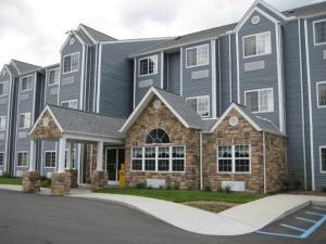 Microtel Inn & Suites by Wyndham Hazelton/Bruceton Mills في Hazelton: عمارة سكنية كبيرة امامها ممر