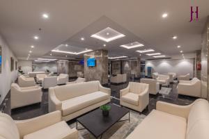 a waiting room with white couches and chairs at Manazel Al Zaireen Hotel in Mecca