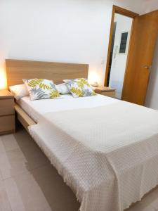 - une chambre dotée d'un grand lit avec des draps et des oreillers blancs dans l'établissement Apartament Ca l'Eudald Parelles, à Besalú