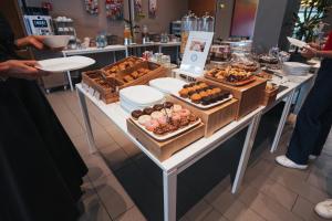 - une table avec de nombreux types de pâtisseries dans l'établissement Mod 05 Bike Hotel, à Castelnuovo del Garda