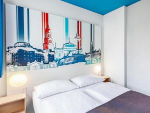 a bedroom with a city skyline mural on the wall at B&B Hotel Hamburg City-Ost in Hamburg