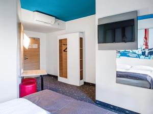 Zimmer mit 2 Betten und einem Flachbild-TV in der Unterkunft B&B Hotel Hamburg City-Ost in Hamburg