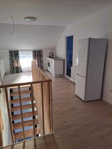 kuchnia z lodówką i schody w pokoju w obiekcie PENSIUNEA NASUI w mieście Vişeu de Sus